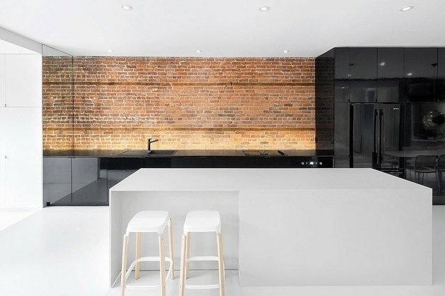 modern minimalistisk köksdesign obehandlad tegelvägg högglansfronter