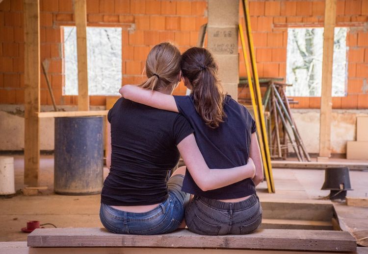 renovera köket flyttar flyttkvinnor som omfamnar sittande byggarbetsplats