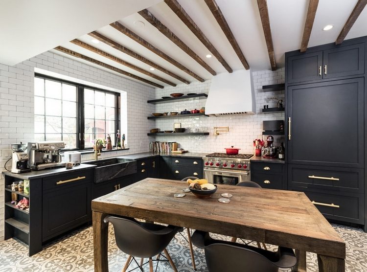 svarta köksmöbler i kombination med ett rustikt träbord och designstolar