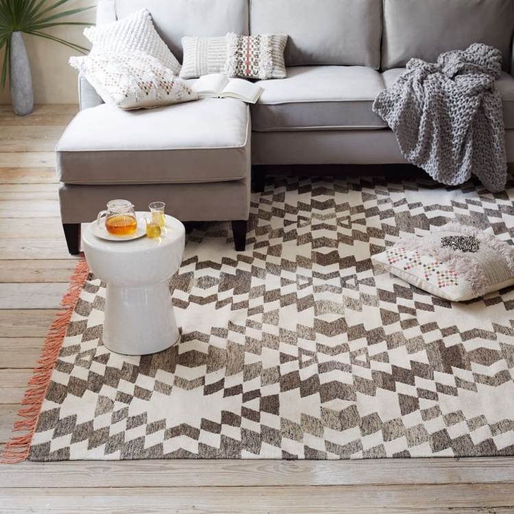 Kilim-matta-modern-soffa-grå-svart-vit-kuddar-tak-golvbrädor