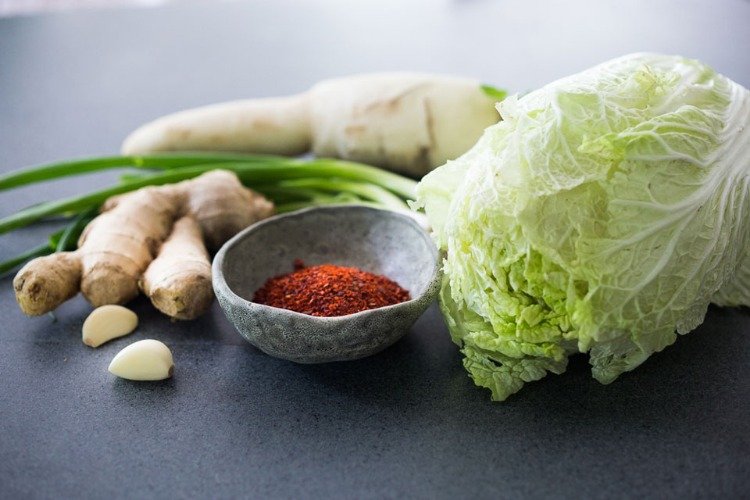 ingredienser för kimchi som paprikapulver kinakålsklyftor av vitlök och ingefära knöl