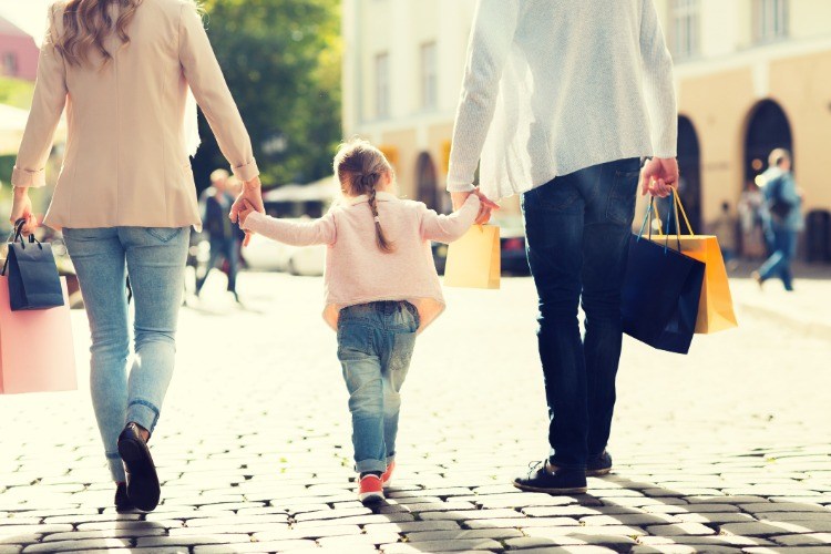 Familj med barn som handlar med påsar på grund av reklam och en shoppingrunda
