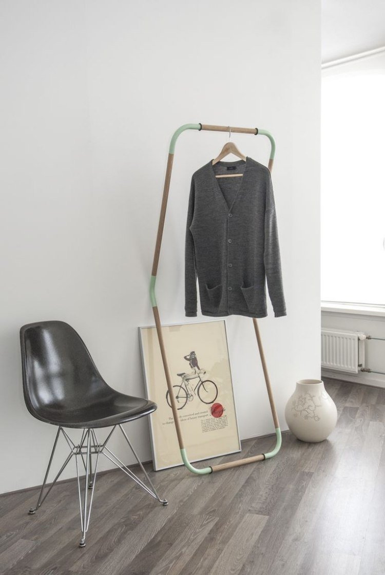 klädstång-garderob-kreativ-design-sprucken-svart-laminat-golv-grå-vägg-vit