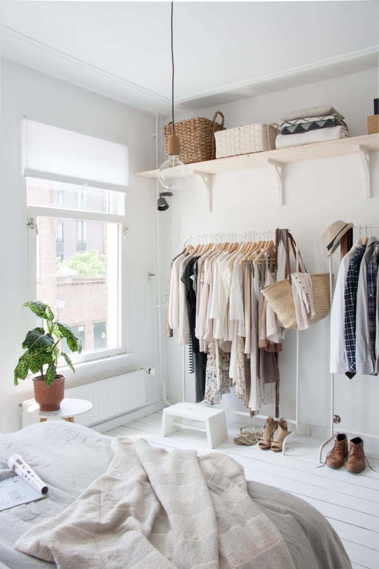 Kläder-skena-garderob-sovrum-vit-säng-fönster-trägolv-vit-dekoration-kläder