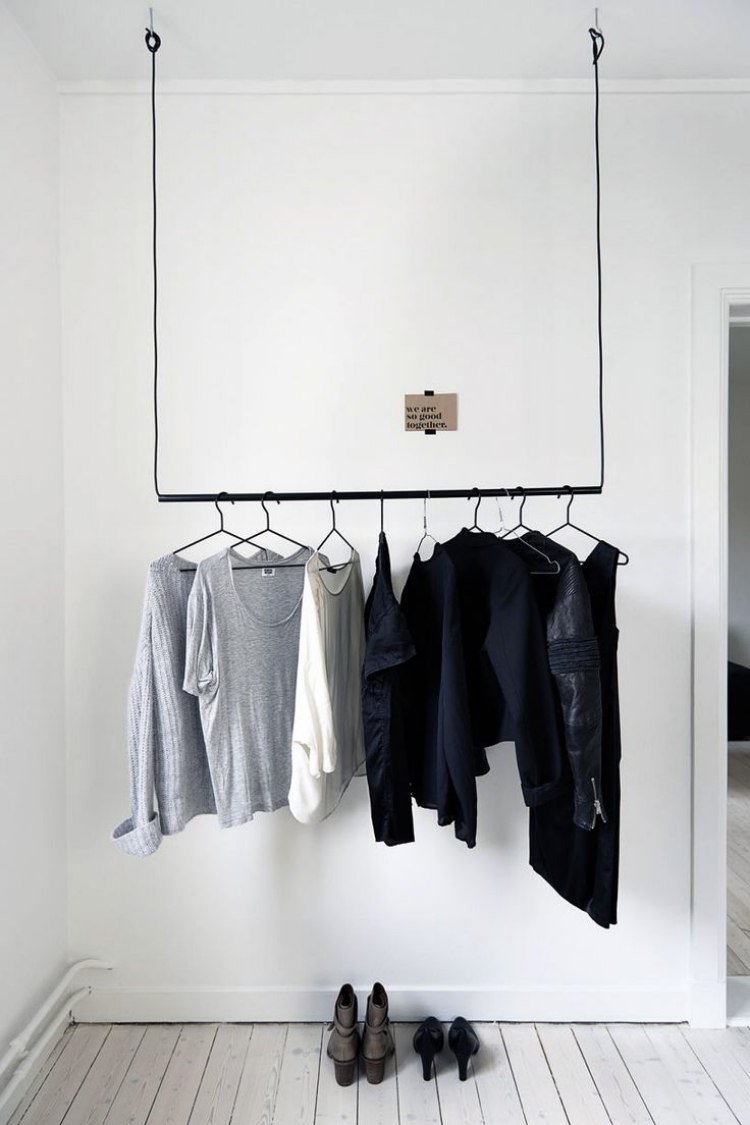 Klädskena-garderob-hängande-vit-svart-kläder-trägolvmålade