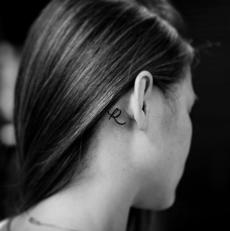 kvinna små tatueringsmotiv för bakom örat initialer hårfäste