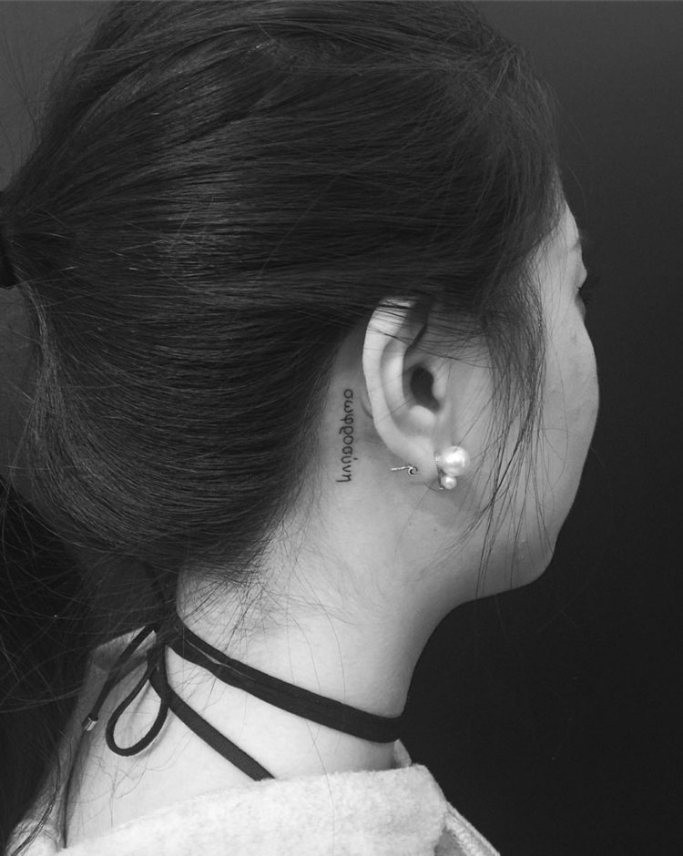 små tatueringsmotiv typ vertikala diskret svartvit kvinna bakom örat