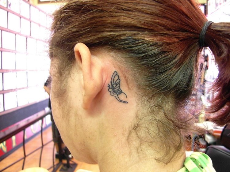 kvinna liten tatuering öron fjäril monokrom