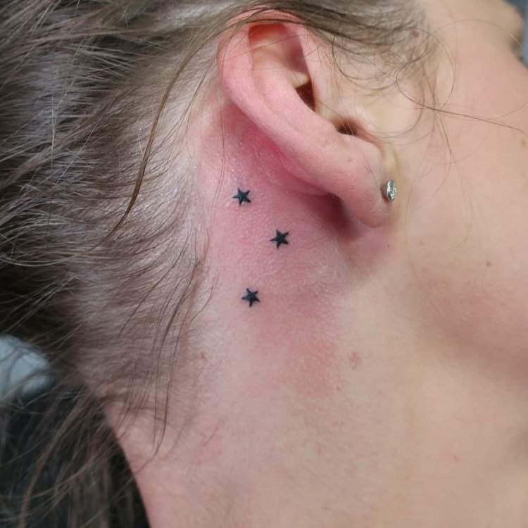 små tatueringsmotiv stjärnor bakom örat för kvinnor
