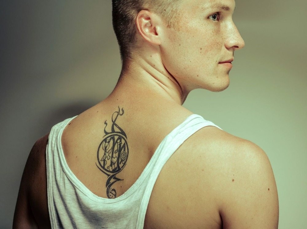 ung blond man med tillbaka tatuering drömfångare