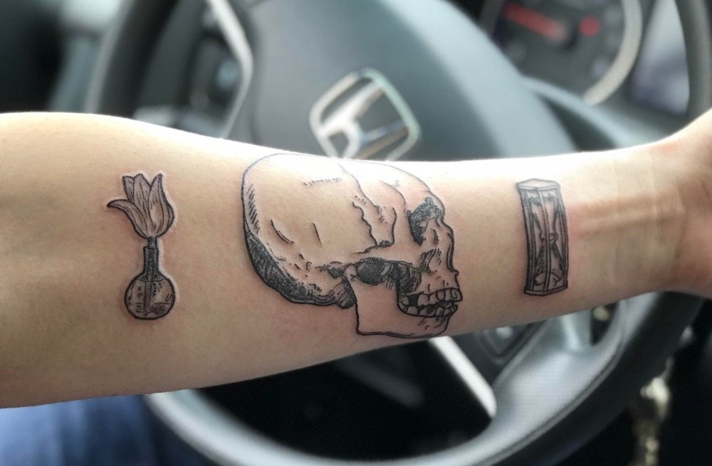 tottenkopf tatuering kombineras på armen som små tatueringar män i bilen