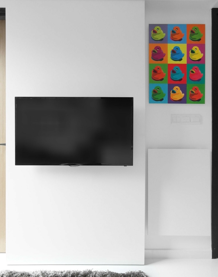 liten-lägenhet-möblering-vardagsrum-tv-vit-hopfällbar-bord-vägg-färgglad-bild-grå-matta