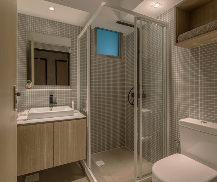 liten-lägenhet-möblering-badrum-mosaik-dusch-skåp-trä-underskåp-vit-bänk-handfat-spegel
