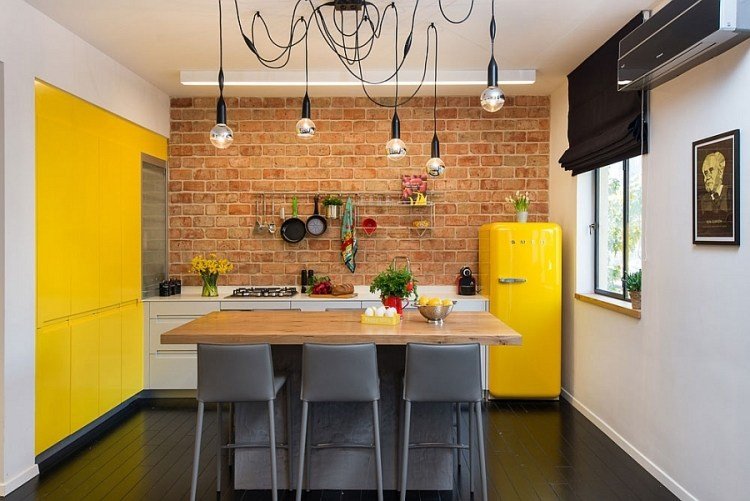 Inred en liten lägenhet-kök-tegelvägg-gul-accenter-kök-ö-svarta stolar