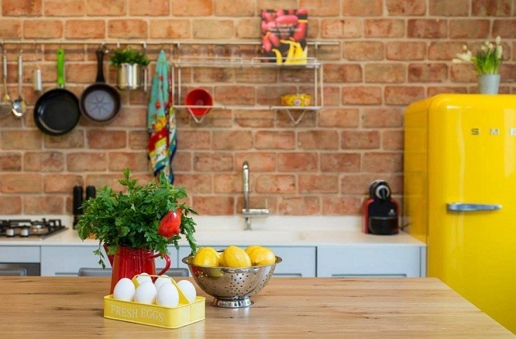 Liten lägenhet -inredd-kök-tegel-vägg-gul-smeg-kylskåp
