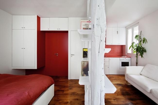 Liten lägenhet inrättade rött vitt förvaringsutrymme ovanför