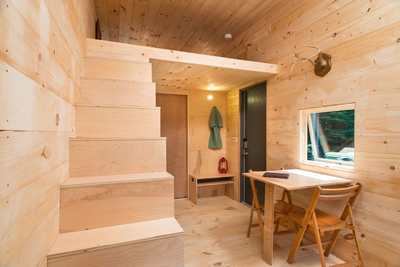 litet hus-trappor-andra-vardagsrum-bord-trä-vägg-garderob-fönster-enkel-design