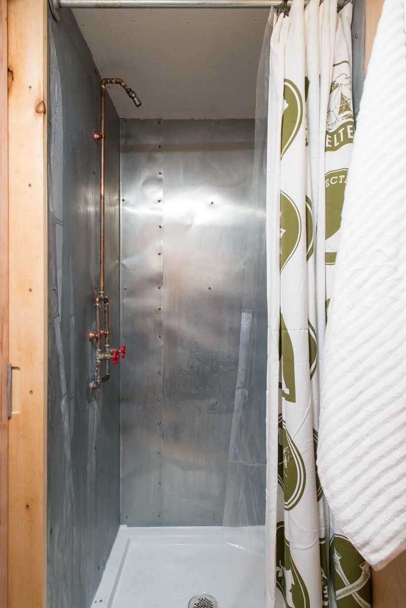 litet hus-dusch-stål-beklädnadsbeslag-rör-minimalistisk-enkel-design
