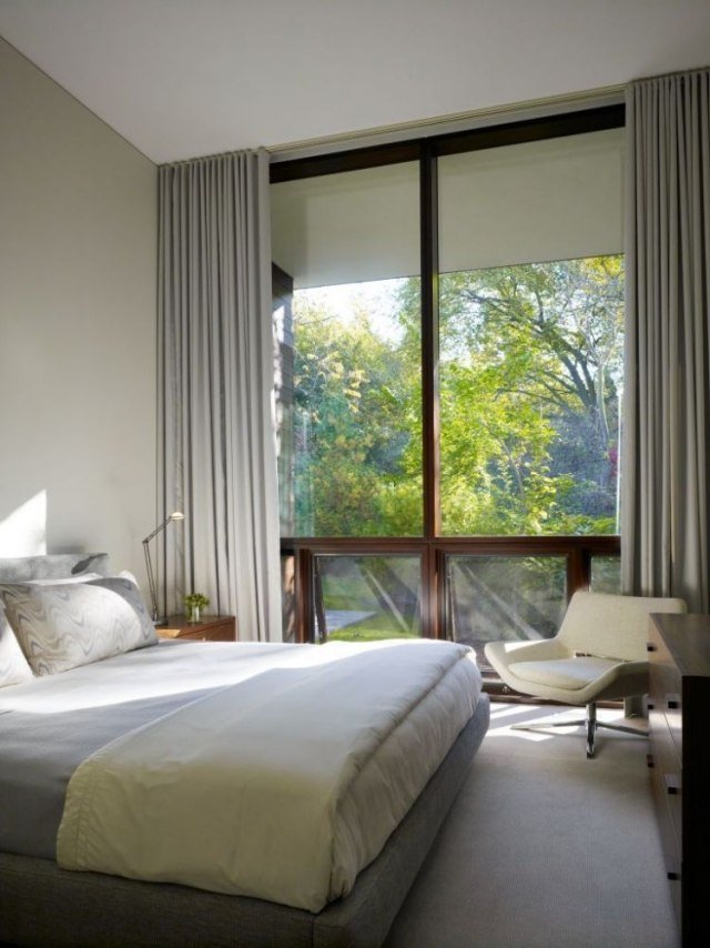 litet sovrum med stort fönster fram ljusgrått träramfönster