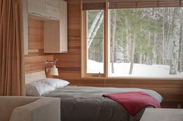 litet sovrum-stort-fönster-träpanel-skåp-över-säng