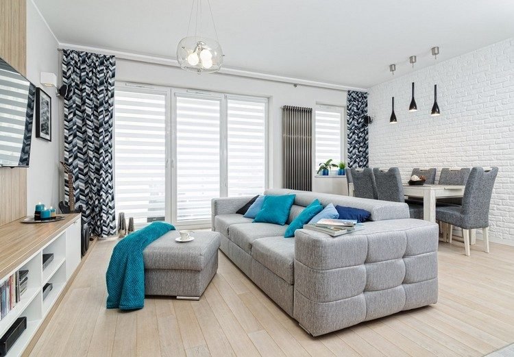 Litet vardagsrum / matsal inrett trägolv-grå-soffa-vit tegelvägg