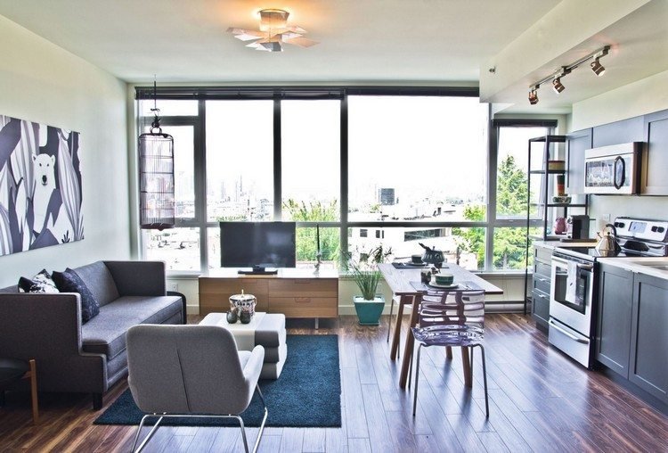 litet-vardagsrum-matsal-trä-golv-grå-soffa-blå-matta-transparent-matsal-stolar