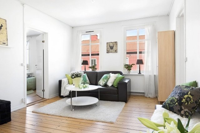 vardagsrum-modern-möblering-planka-golv-vit-grön-accent-kuddar
