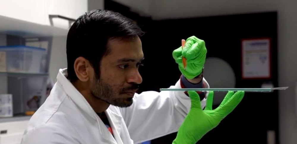 Forskares test resulterar i laboratorium med gröna gummihandskar
