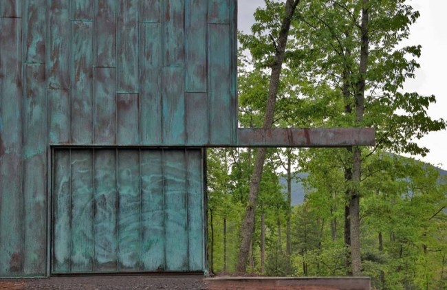 Ekologiskt hus i skogsmodern fasaddesign med patinerat koppar