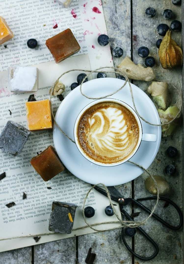 Specialkaffe i kopp vänd av rustika föremål på boksidor
