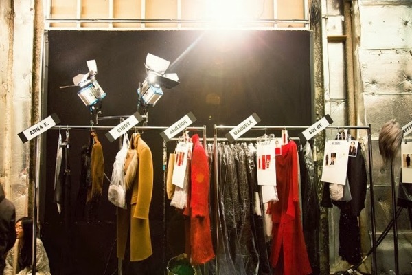hängde-kläder-backstage-med-lampor