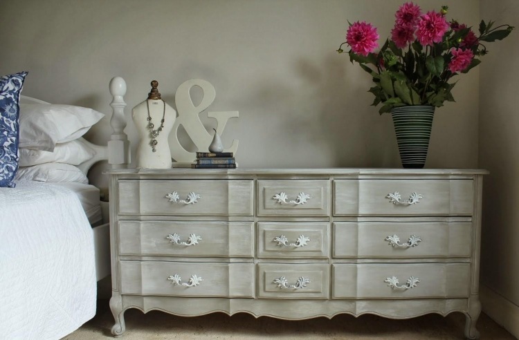 Byrå i lantlig stil - vit - sovrum - sängbord - handtag - rustik - blomma - vas - säng - sängkläder