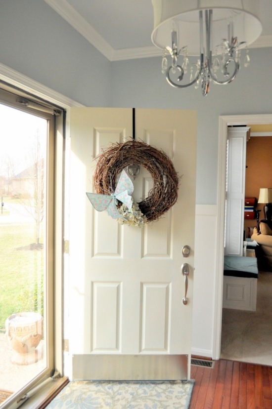 Dekorera dörren-med en krans-kreativt design-från grenar-vinstockar