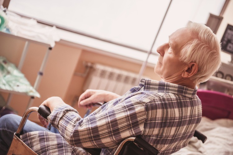 gubben sitter i en rullstol som patient på sjukhuset