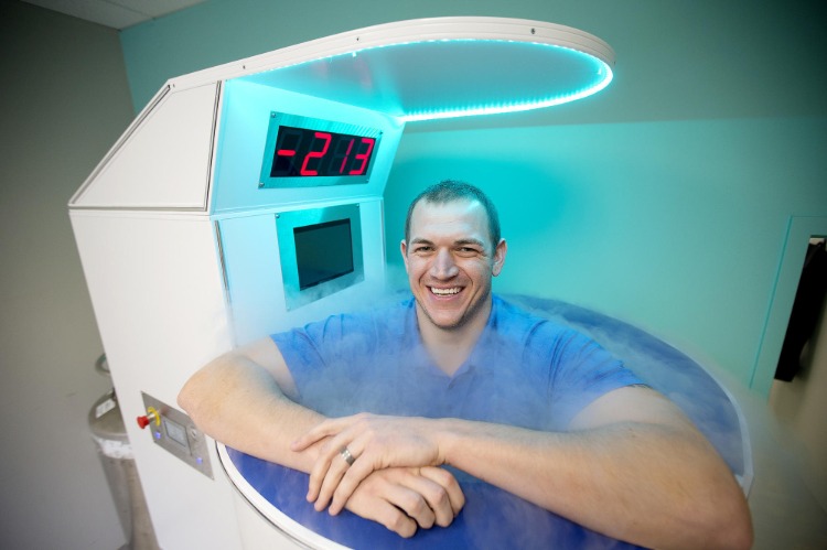 Doktor står i kryokammaren och skrattar vid låg temperatur med korta ärmar