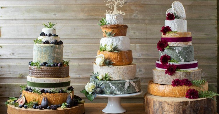 Stor tårta för bröllopet gjord av osthjul - med frukt och blommor