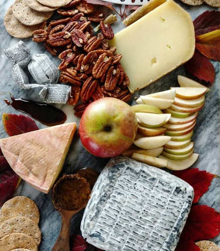 Ordna ostfatet marmor-tallrik-blad-pekannötter-äpple-hela-äppelskivor-bitar ost-sked-trä-5