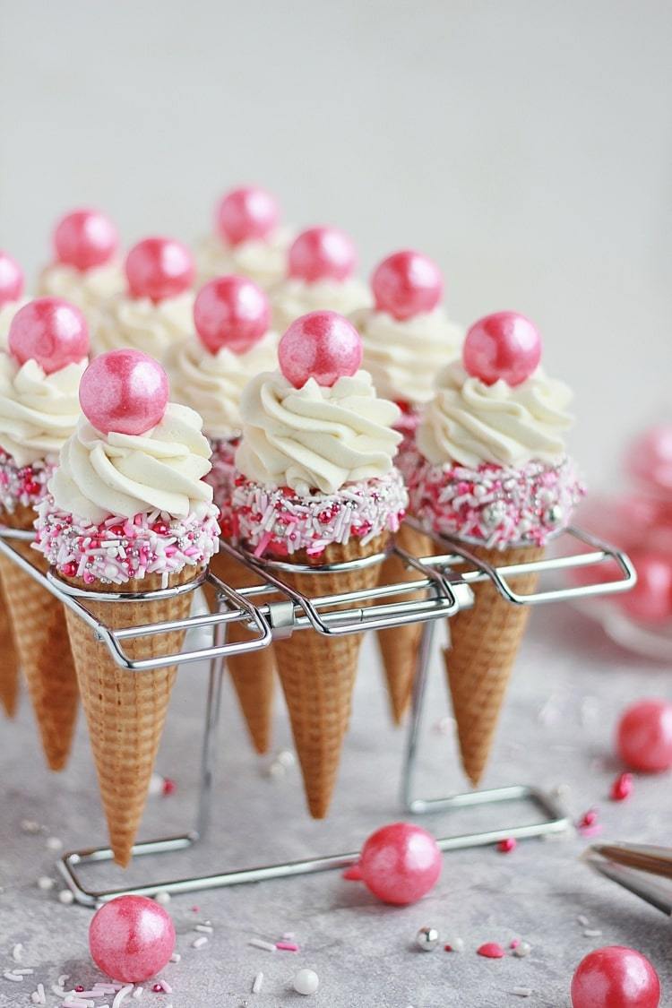 Läckra muffins i spetsiga glasskott med rosa strössel och ätbara pärlor
