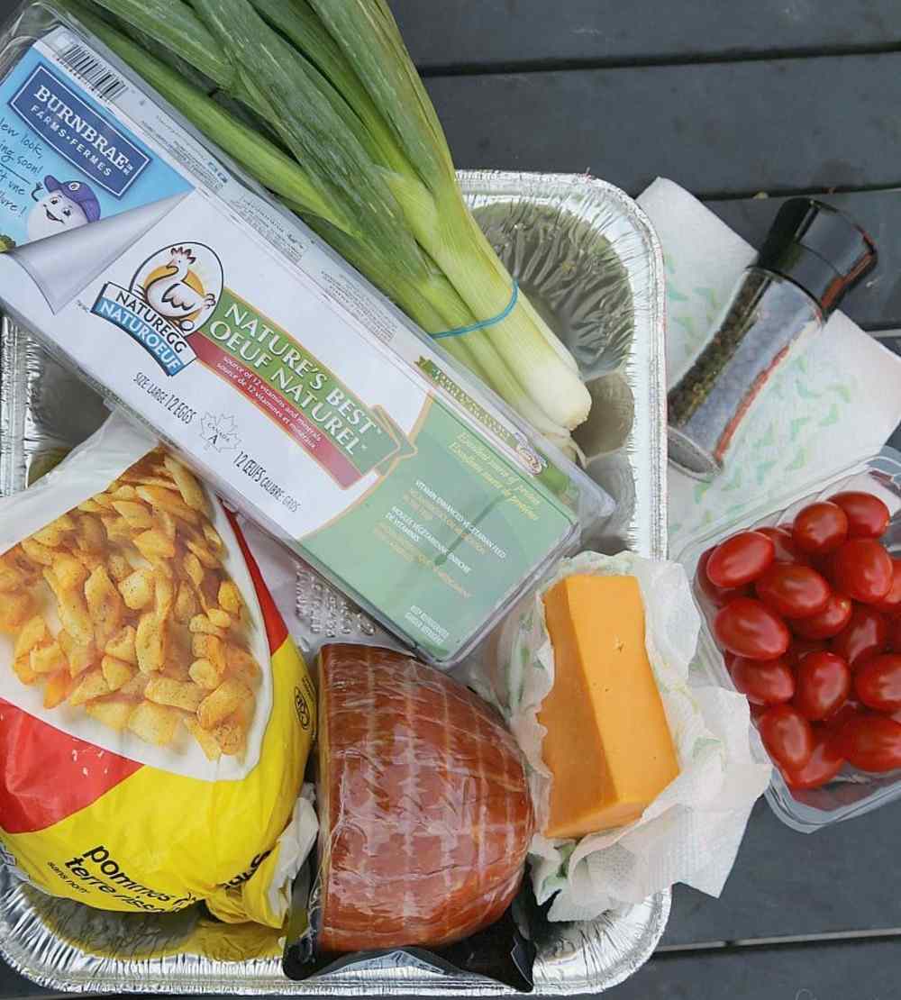 Ingredienser och produkter för camping Matlagning från körsbärstomater, cheddarost, hashbrowns, ägg, peppar