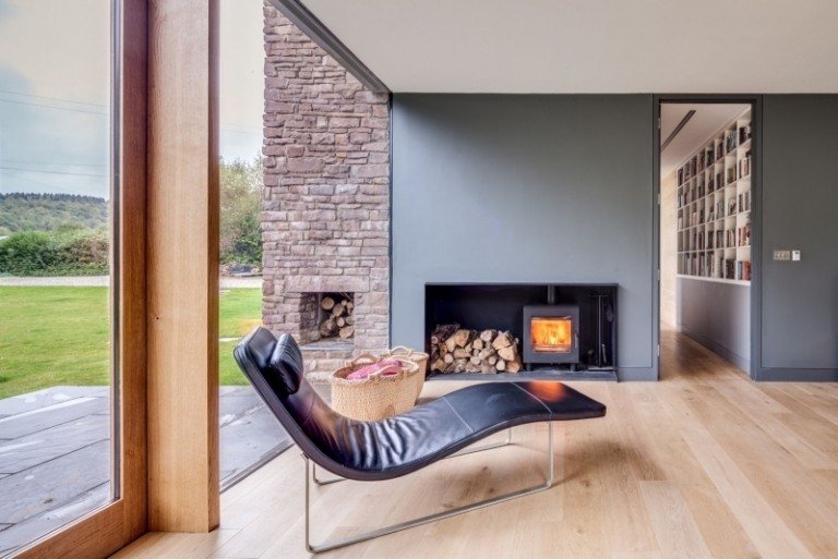 lanthus-stil-modern-arkitektur-inredning-lounge-solstol-öppen spis-ved-vägg-färg-grå-natursten trägolv