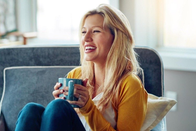 blond kvinna dricker svart te för vita tänder och vackert leende