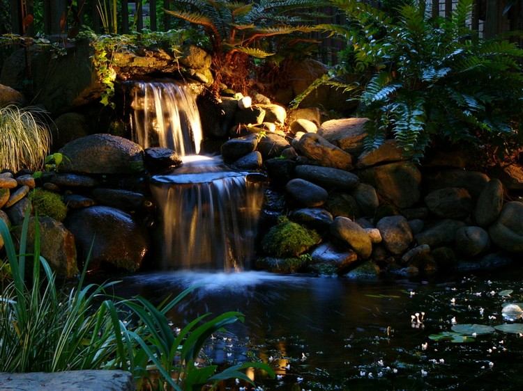 damm-belysning-led-vattenfall-stenar-växter-kväll-belyst-trädgård