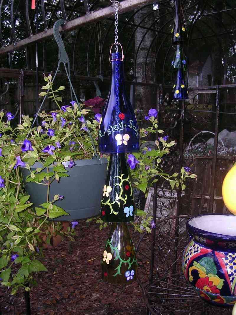 Vinflaskor i trädgårdsinredningen hänger flaskhalsfärgblommor