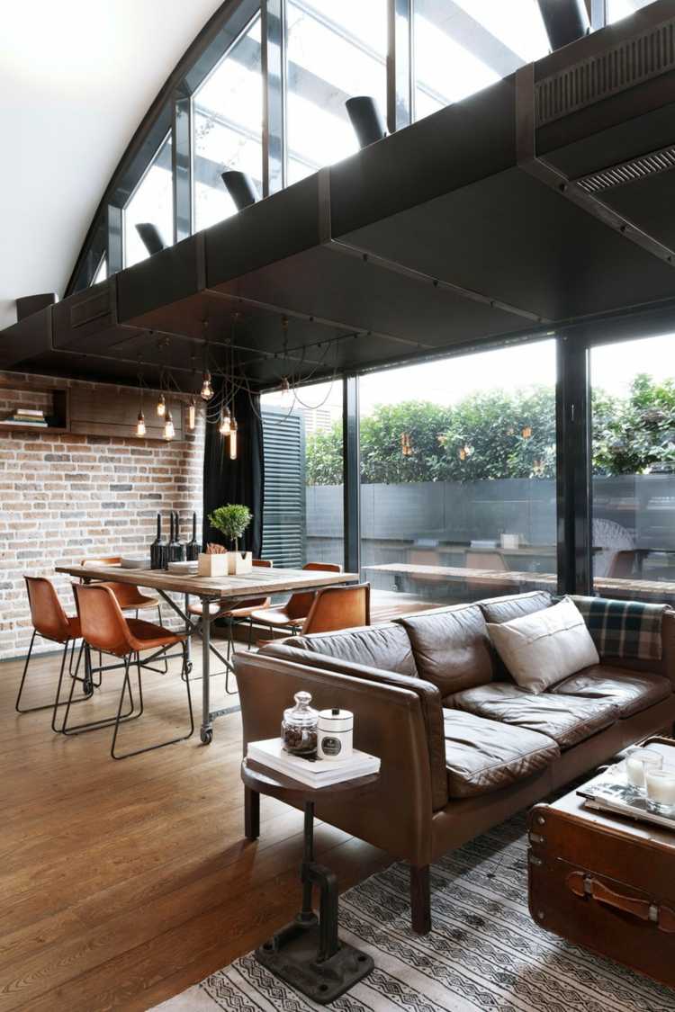 Loft med betong och klinkerbrunt läder soffa matbord lägenhet
