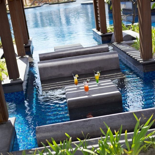 Sittmöjligheter i poolvatten modern design lyxhotell komplex