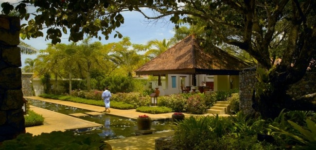 Exotiska resmål Malaysia halmtak bungalow vatten damm frodigt landskap