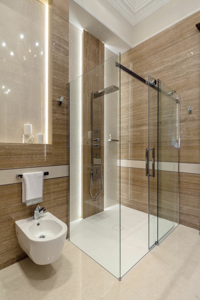 lyxigt badrum beige kakel högglans duschglas toalett