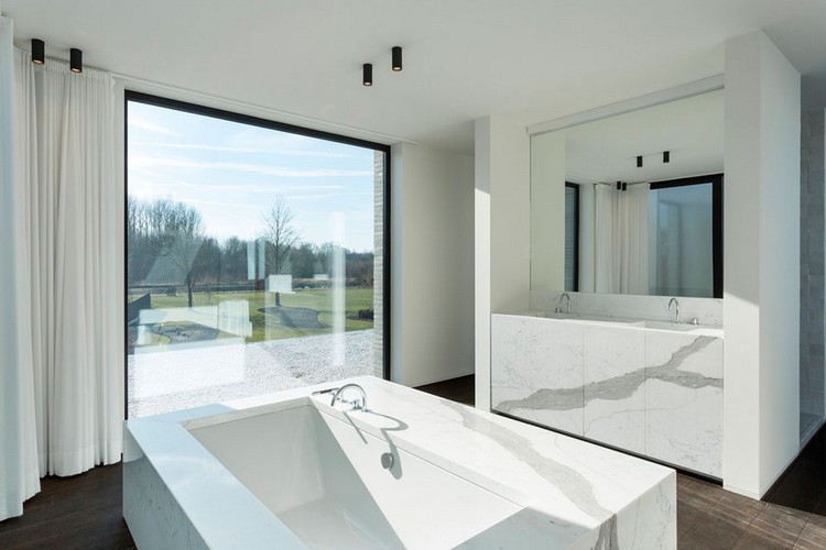 rymligt badrum med marmorbadkarfönster