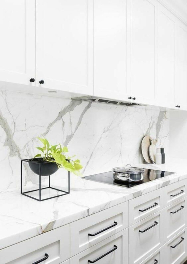Bakre vägg i marmor i vita detaljer av köksdesigner