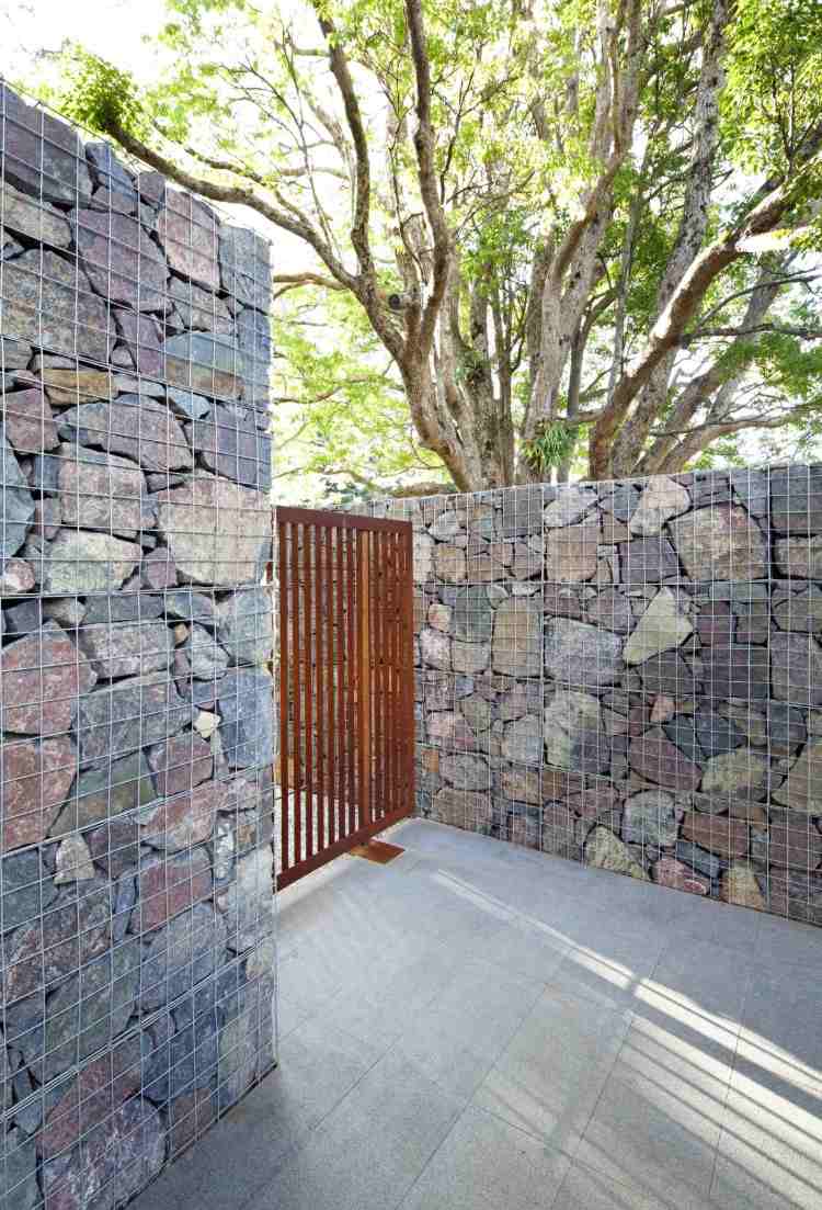 gabion som ett väggstängselkombination med rostfritt stålgaller skapar en minimalistisk atmosfär på utsidan